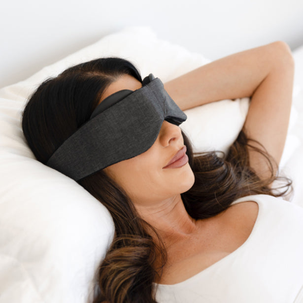 Woman Wearing Sleep Mask Resting Head On Pillow