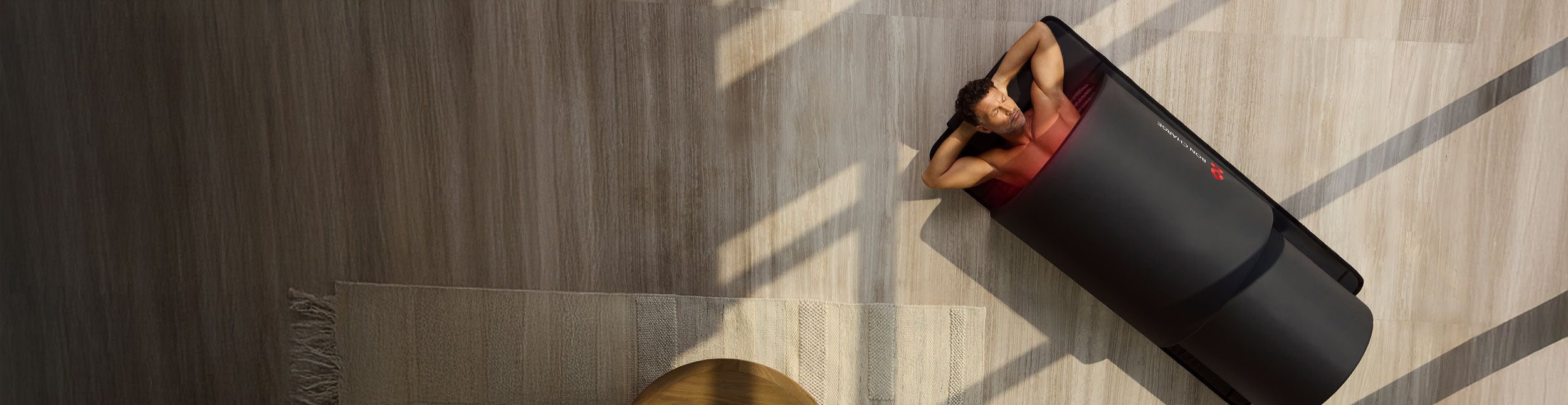 Man Relaxing In Infrared PEMF Sauna Dome On Wood Floor